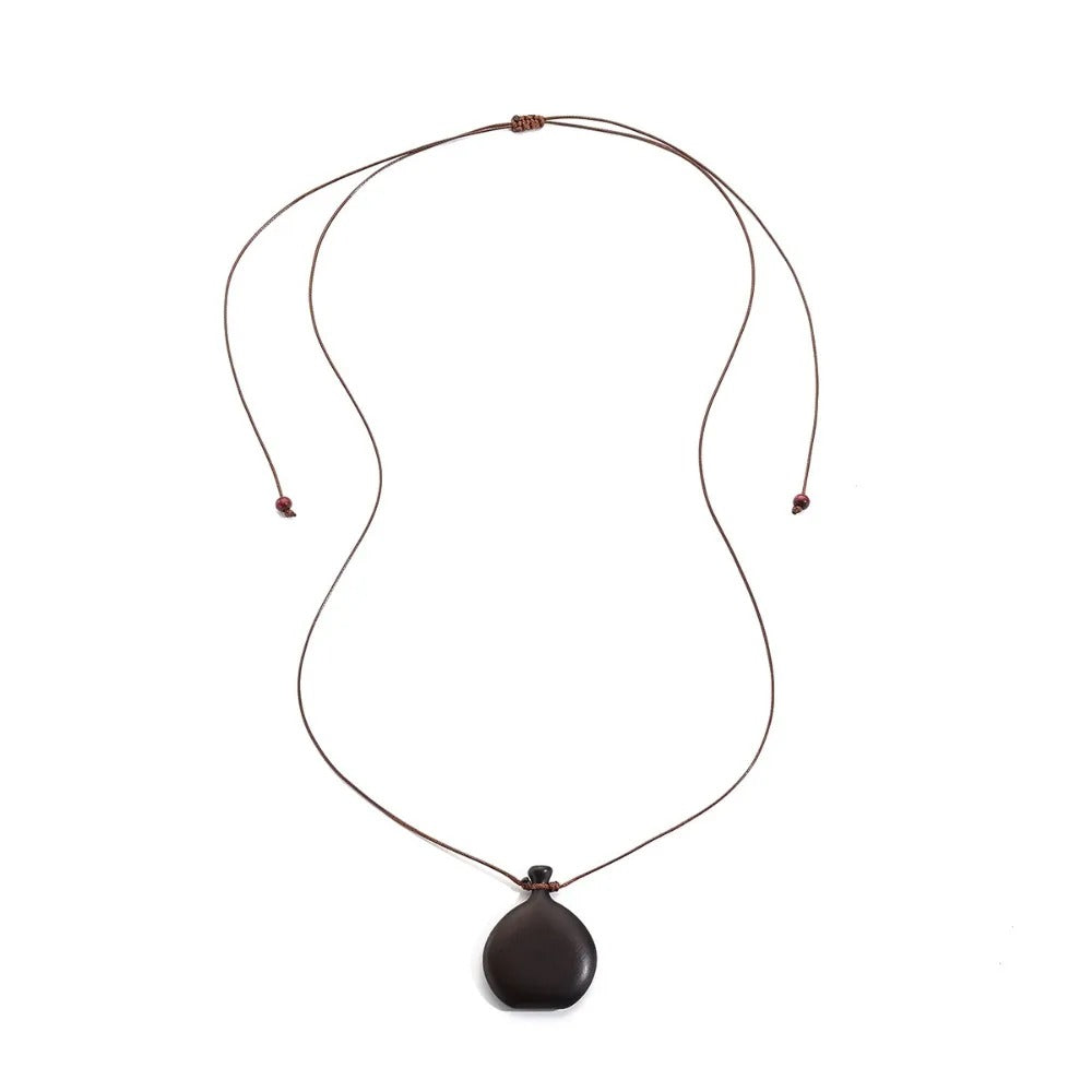Collier long mixte en bois naturel ébène et santal avec pendentif élégant de style bohème et chic.