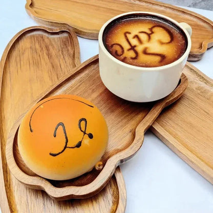 Petite assiette en bois d'acacia servant un café et une pâtisserie, idéale pour le petit-déjeuner ou une pause gourmande.