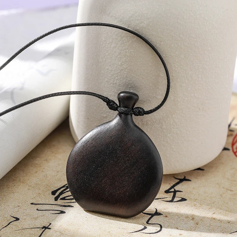 Collier long mixte en bois naturel de santal noir avec pendentif élégant de style bohème et chic.
