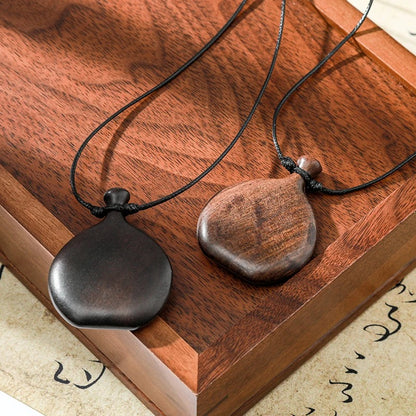 Collier long mixte en bois naturel ébène et santal avec pendentif élégant de style bohème et chic.