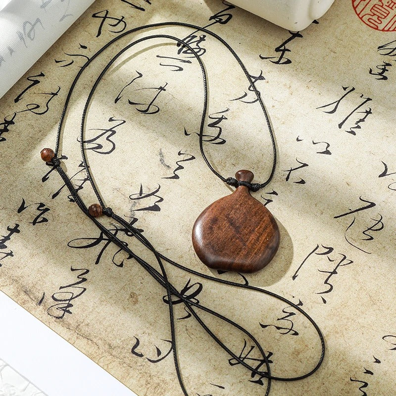Collier long mixte en bois naturel ébène et santal avec pendentif élégant de style bohème et chic.