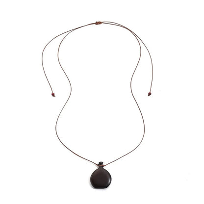 Collier long mixte en bois naturel ébène et santal avec pendentif élégant de style bohème et chic.