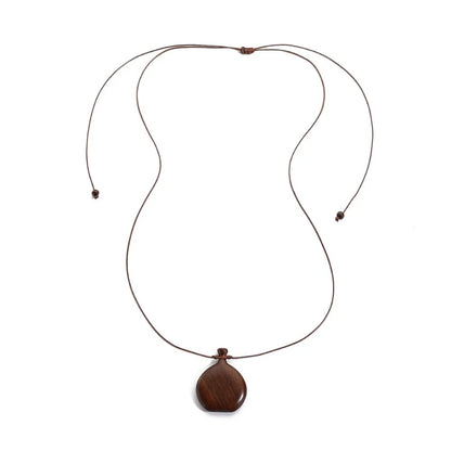 Collier long mixte en bois naturel ébène et santal avec pendentif élégant de style bohème et chic.